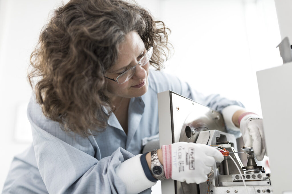 ZSW Mitarbeiterin verschraubt die Solarzellenhalterung im REM-Gerät